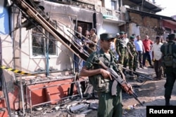 Sri Lanka's army soldiers stand guard near a burned house after a clash between two communities in Digana, central district of Kandy, Sri Lanka, March 6, 2018.