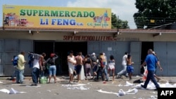 People loot a supermarket in Maracay, Aragua state, Venezuela, June 27, 2017. 