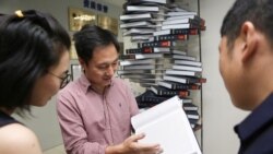 Scientist He Jiankui shows "The Human Genome", a book he edited, at his company Direct Genomics in Shenzhen, Guangdong province, China August 4, 2016. Picture taken August 4, 2016.