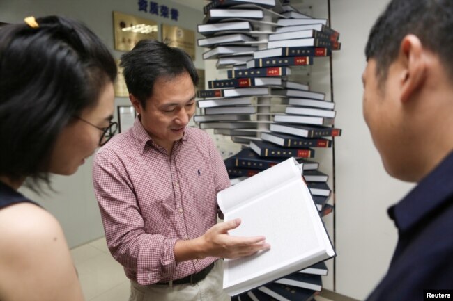 Scientist He Jiankui shows "The Human Genome," a book he edited, at his company Direct Genomics in Shenzhen, Guangdong province, China August 4, 2016.