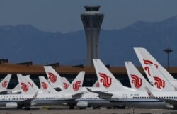 FILE - This file photo taken on March 27, 2020 shows Air China planes parked on the tarmac at Beijing Capital Airport. China's big state-controlled airlines and oil firms said they suffered deep losses during the first quarter of 2020.