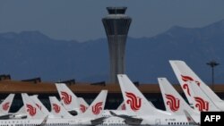 FILE - This photo taken March 27, 2020, shows Air China planes parked on the tarmac at Beijing Capital Airport. 