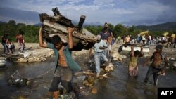 La gente cruza desde San Antonio del Táchira en Venezuela a Cúcuta en Colombia a través de "trochas" -caminos legales- cerca del puente internacional Simón Bolívar.