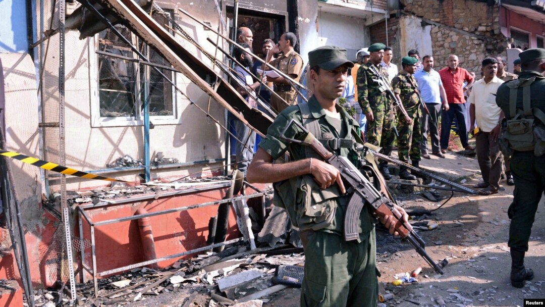 Sri Lanka's army soldiers stand guard near a burned house after a clash between two communities in Digana, central district of Kandy, Sri Lanka, March 6, 2018.