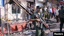 Sri Lanka's army soldiers stand guard near a burned house after a clash between two communities in Digana, central district of Kandy, Sri Lanka, March 6, 2018.