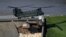 A Chinook helicopter drops sand bags on top of the dam after a nearby reservoir was damaged by flooding, in Whaley Bridge, Britain, Aug. 2, 2019.