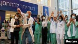 Equipos médicos celebran que recibirán sus vacunas contra el coronavirus, al iniciarse la campaña de vacunación en Israel, en el Centro Médico Souraski, en Tel Aviv el 20 de diciembre.