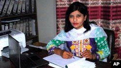 FILE - Krishna Kumari works in her office in Hyderabad, Pakistan, Feb. 12, 2018.