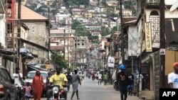 FILE .—People walk through a road in Freetown on June 18, 2023. Sierra Leone was calm today, November 27, 2023 after a weekend attack by gunmen on a military barracks.