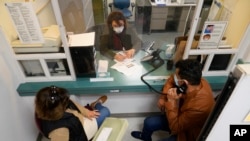 Mohammad Attaie and his wife Deena, newly arrived from Afghanistan, get assistance from medical translator Jahannaz Afshar making a doctor's appointment at the Valley Health Center TB/Refugee Program in San Jose, California on Dec. 9, 2021.