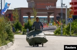 A man walks with a cart at Chinese part of the China-Kazakhstan Horgos International Border Cooperation Center (ICBC), in Horgos, China, May 12, 2017.