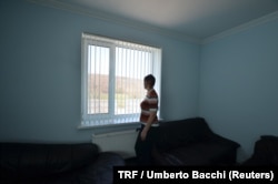 FILE - Laura, a survivor of slavery who did not want to be identified, looks outside a window of rehabilitation center for victims of violence in Palaria, Moldova, April 4, 2018.