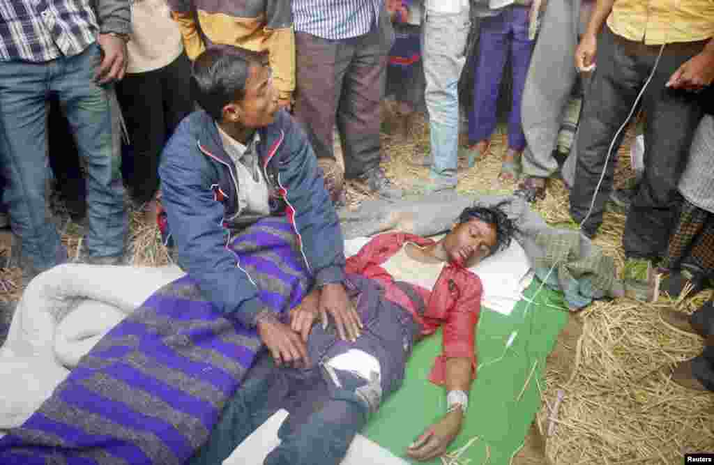 Villagers tend to a man after he was injured during a clash with police in Gaibandha, Bangladesh, Jan. 5, 2014. 