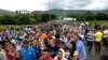 FILE - People cross the Colombian-Venezuelan border over the Simon Bolivar international bridge in Cucuta, June 10, 2019.