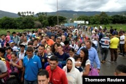 FILE - People cross the Colombian-Venezuelan border over the Simon Bolivar international bridge in Cucuta, June 10, 2019.