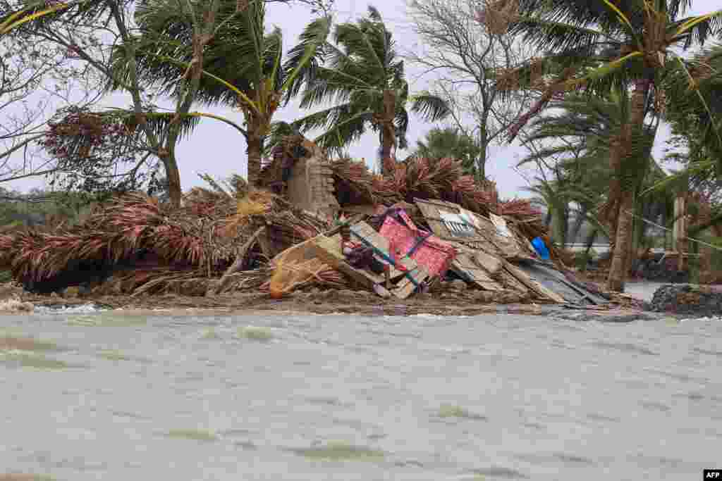 A man rests on the debris of his home surrounded by floodwater a week after Cyclone Amphan ravaged the area in Koyra, Satkhira, May 27, 2020, killing more than 100 people and leaving hundreds of thousands homeless.