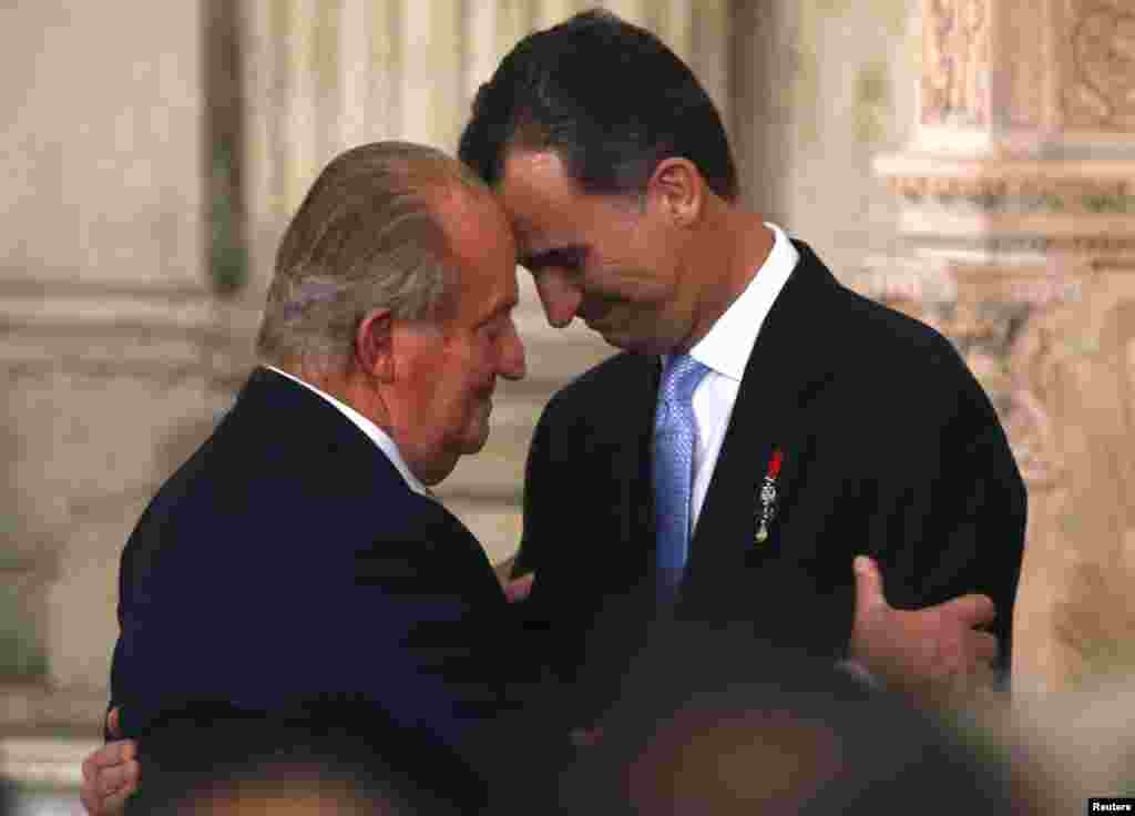 Spain&#39;s King Juan Carlos and his son Crown Prince Felipe (R) hug each other at the signature ceremony of the act of abdication at the Royal Palace in Madrid.&nbsp; The king abdicated in favor of his son Felipe.