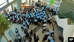 Police officers gather at the lobby of headquarters of Apple Daily in Hong Kong Thursday, June 17, 2021. (Apple Daily via AP)