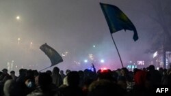 Protesters wave flags during a rally in Almaty, Kazakhstan, Jan. 4, 2022.
