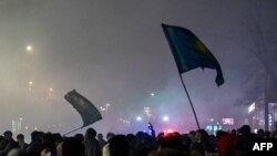 FILE - Protesters question    flags during thousands-strong march successful  Almaty, Kazakhstan's largest city, aft  protests that began implicit    substance  prices threatened to spiral retired  of control, Jan. 4, 2022.