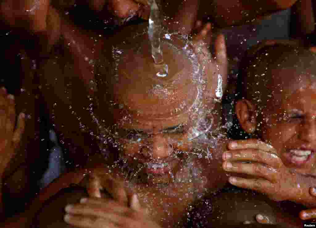 Young Hindu priests take a holy bath together as part of a ritual during the sacred thread festival at the Pashupatinath temple in Kathmandu, Nepal. Hindus take holy baths and change their sacred threads, also known as janai, for protection and purification during the festival.