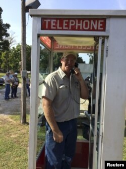 Patrick Smith, who repaired a rare phone booth after it was hit by a car, is pictured inside the structure in St. Prairie, Arkansas in this 2014 handout photo released on Nov. 23, 2015 and provided by David Parks.