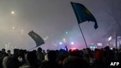 Protesters wave flags during a rally in Almaty, Kazakhstan, Jan. 4, 2022.