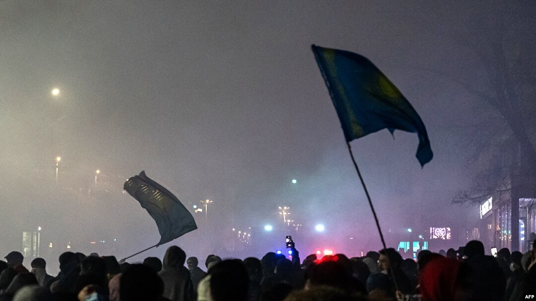 Para pendemo mengibarkan bendera dalam aksi unjuk rasa di Almaty, Kazakhstan, pada 4 Januari 2022. (Foto: AFP/Abduaziz Madyarov)