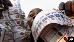 Supporters of oppositions candidate Etienne Tshisekedi parade what they claim are badly printed fraudulent photocopies of election ballots they say they found in the Bandal commune in Kinshasa, Democratic Republic of Congo, Nov. 28, 2011.