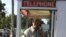 Patrick Smith, who repaired a rare phone booth after it was hit by a car, is pictured inside the structure in St. Prairie, Arkansas in this 2014 handout photo released on Nov. 23, 2015 and provided by David Parks.