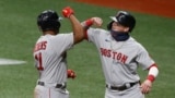 FILE - Boston Red Sox third baseman Rafael Devers gets an elbow bump from the batboy (right) after hitting a two-run home run at Tropicana Field, Sept. 10, 2020, St. Petersburg, Florida. (Reinhold Matay-USA TODAY Sports)