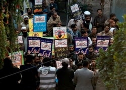 FILE - Angry protesters hold a demonstration against an independent newspaper 'Dawn' outside newspaper's office in Islamabad, Pakistan, Dec. 6, 2019.