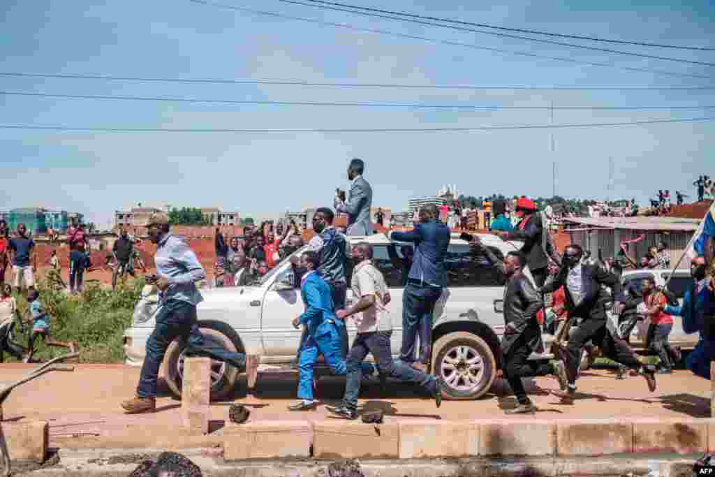 Musician-turned-politician Bobi Wine (on top of car) greets supporters as he makes his way to be officially nominated as a presidential candidate, in Kampala, Uganda.