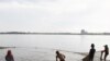 Cambodian fishermen move their fishing net from the Mekong River as they catch fish on the outskirts of Phnom Penh.