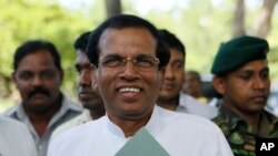 Sri Lankan Health Minister Maithripala Sirisena acknowledges the gathering as he arrives to address the media in Colombo, Sri Lanka, Friday, Nov. 21, 2014. 