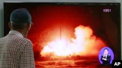FILE - A man watches a TV news program showing a file picture of a missile launch conducted by North Korea, at Seoul Railway Station in Seoul, South Korea.