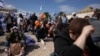 People react at the so-called "Hostages Square" in Tel Aviv, Israel, Feb. 20, 2025, as the bodies of four Israeli hostages, including a mother and her two children, are handed over by Hamas to the Red Cross in Gaza.