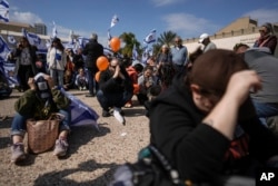 People react at the so-called "Hostages Square" in Tel Aviv, Israel, Feb. 20, 2025, as the bodies of four people, including two children, are handed over by Hamas to the Red Cross in Gaza.