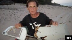 Warga Madagaskar Blaine Gibson menunjukkan potongan pesawat yang kemungkinan berasal dari pesawat Malaysia Airlines MH370 yang hilang, di pulau Nosy Boraha. (Foto: Dok)