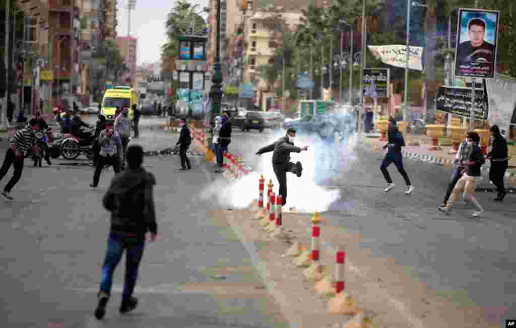 An Egyptian protester kicks a tear gas canister fired by riot police in Port Said, Egypt, March 7, 2013. 
