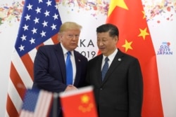 FILE - President Donald Trump poses for a photo with Chinese President Xi Jinping during a meeting on the sidelines of the G-20 summit in Osaka, Japan, June 29, 2019.