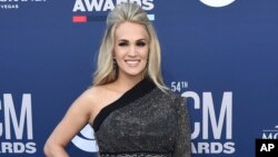 FILE - Carrie Underwood poses for photos at the 54th annual Academy of Country Music Awards in Las Vegas, April 7, 2019.