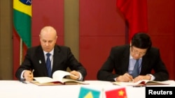 3月26日巴西财政部长曼蒂加，左，和中国财政部长楼继伟在南非德班金砖五国会议上签署备忘录