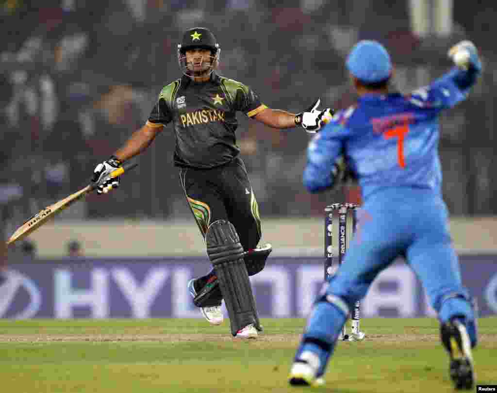 بھارتی کپتان دھونی پاکستانی کپتان محمد حفیظ کو آوٹ کرنے کے لیے گیند پھینک رہے ہیں