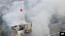Rescue workers work to extinguish a fire at a collapsed building in central Christchurch, Feb 22 2011