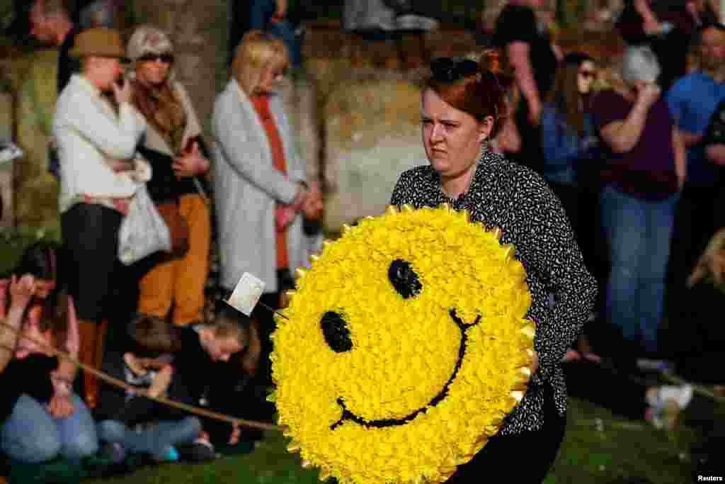 A floral wreath in the shape of a smiley face is carried during the funeral of British singer Keith Flint of techno group &#39;The Prodigy,&#39; in Braintree, Essex, Britain.