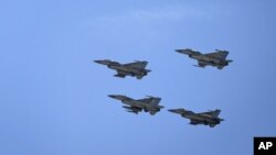 Jordanian Air Force fighter jets fly during the funeral of slain Jordanian pilot, Lt. Muath al-Kaseasbeh, at his home village of Ai, near Karak, Jordan, Wednesday, Feb. 4, 2015.