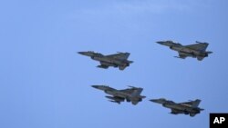 Aviones de guerra jordanos vuelan en formación durante el funeral del piloto Muath al-Kaseasbeh, cerca de Karak, Jordania.