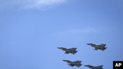 Jordanian Air Force fighter jets fly during the funeral of slain Jordanian pilot, Lt. Muath al-Kaseasbeh, at his home village of Ai, near Karak, Jordan, Wednesday, Feb. 4, 2015.