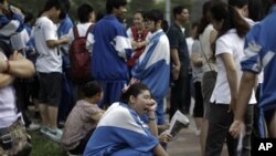 Chinese students wait to take an annual college entrance examinations. Many more would if not for the Hukou system.